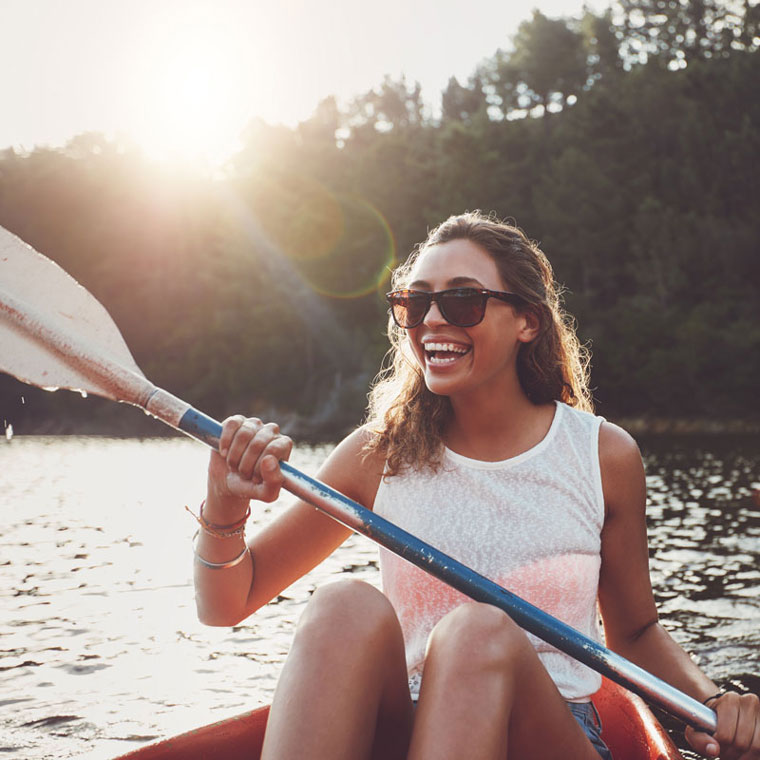 A woman happily river rafting after her orthodontic treatment at OKC Dentistry in Oklahoma City